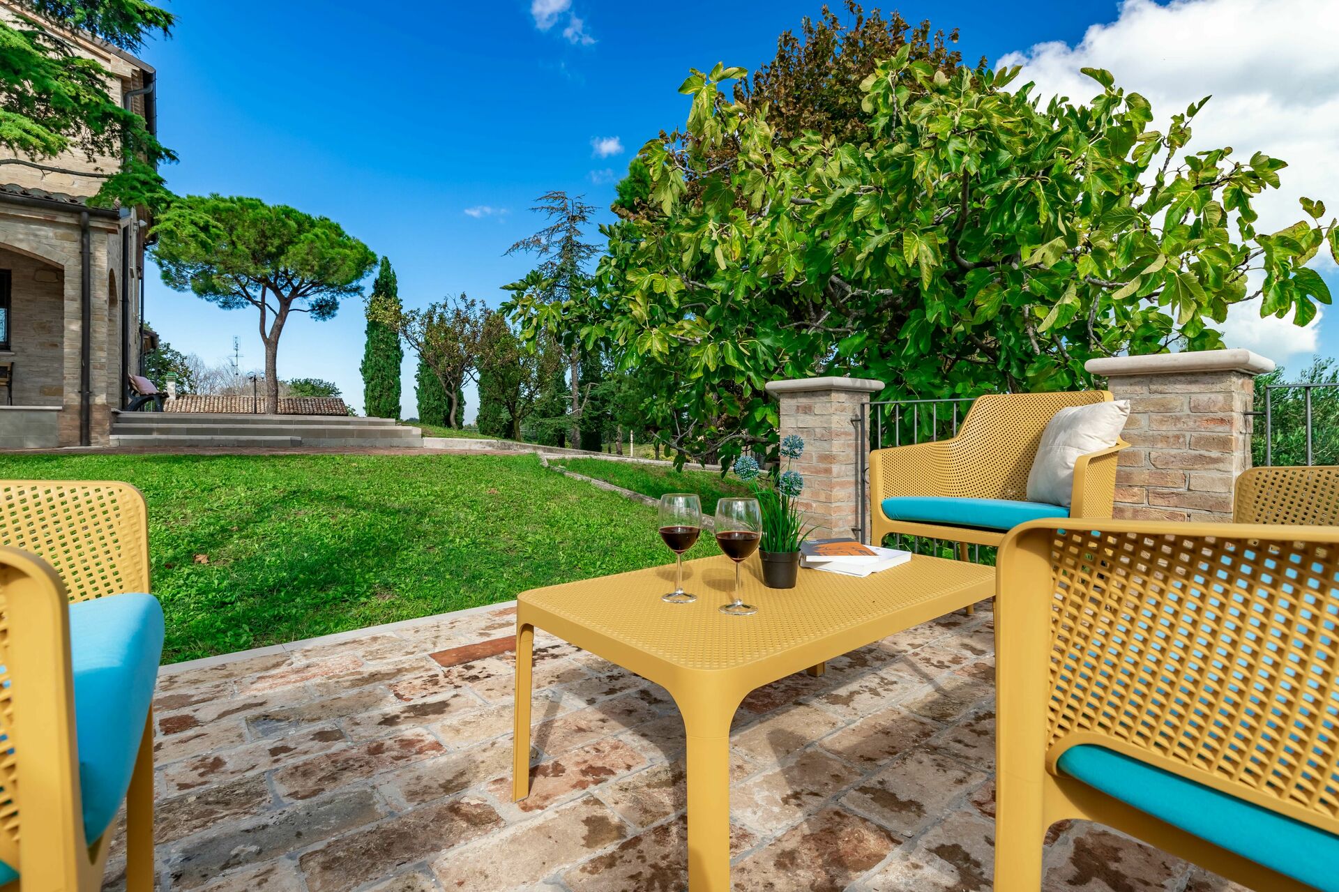 Area relax in giardino con sedute e cipressi